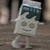 A small square character with a house-shaped body, round eyes, and a smiling mouth stands on two legs against a blurred background.