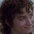 Pixelated close-up of a person with dark curly hair and a light-colored shirt, showing partial facial features including eyes and nose.