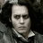 Pixelated grayscale portrait of a person with dark curly hair and a high-collared shirt, next to red pixelated text reading "Sweeney is coming" on black background.