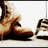 A pair of brown leather boots with laces, positioned on a light surface against a white background.