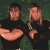 Two pixelated figures in black shirts against a green background with visible dithering and low-resolution rendering artifacts.