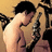Pixelated image of two figures in close physical contact, one with dark hair and light skin, the other with lighter hair and darker skin, against a warm-toned background.