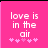 Pink background with white pixelated text 'love is in the air' and five pink asterisks below, showing animation change between frames.