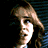 A animation of a person with light brown hair against dark blue horizontal blinds, showing sequential facial expressions and head movements