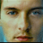 Static 48x48 pixel icon showing a close-up of a person's face with blue eyes, light skin tone, and red lips against a blurred background.