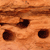 A static pixelated image shows a light brown textured surface with three dark brown circular shapes arranged horizontally.