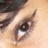 A pixelated close-up of a human eye with visible eyelashes and eyebrow, accompanied by red text on black background reading "You'll never know what lies behind my eyes...".