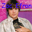 A person in a white jacket and black shirt holds an object against a pink and purple background with blue text reading "Zac Efron is bringing".