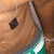 A pixelated close-up of a person's face with brown hair, dark eye, and teal-and-white striped clothing against a warm-toned background.