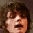 Pixelated image of a person with brown hair and a neutral expression, accompanied by text reading 'Gerard Way is amazing <333' on a black background.