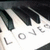 Pixelated anime-style icon with dark hair, white background, and partially visible text elements including 'LOVE' and a circular symbol.