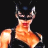 Pixelated static image of a character in a black mask with pointed ears and an orange top against a dark background.