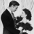 Black-and-white pixelated image of two figures in formal attire, one extending a hand toward the other against a light background.