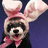 Pixelated image of a character with large ears, pink bow, and dark body against purple background.