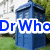 Blue police box with white text 'Dr Who Rules!' overlaid on a grassy background with trees.
