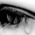 Black-and-white close-up of a human eye with tears, accompanied by pixelated text reading 'my life will never be the same again.'