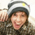 A person wearing a striped beanie with yellow and red accents, smiling widely in three showing slight head movement
