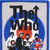 The Who band logo with blue circular background, red flame-like shapes, and black text over a light gray backdrop.