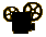 Black silhouette of a film projector with two reels, yellow-brown reel details on light gray background.