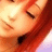 A pixelated close-up of a person's face with closed eyes, red hair, and warm-toned skin under soft lighting.