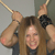 A pixelated image shows a person with long brown hair holding two large, light brown ears attached to a rope, with a neutral background.