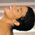 A pixelated image shows a person with light skin and dark hair kissing another person with light skin, both in profile view against a striped background.