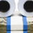 A static pixelated image shows a stylized face with large black circular eyes, white and light gray facial features, blue vertical stripes on the lower portion, and a brownish background.