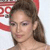A pixelated close-up of a person with brown hair tied back, wearing light makeup, against a red and white background with partial text.