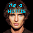 Pixelated image of a person with brown hair and light skin, wearing dark clothing against black background, with cyan text above head.