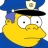 Yellow cartoon character with large white eyes and black pupils wearing a blue police hat with a silver badge and black brim.
