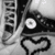 Black-and-white image with a heart outline, circular eye-like shape, and partial text on the left side.