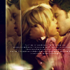 A static image shows two people in a close embrace, their faces nearly touching, with warm lighting and a blurred background.