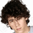 A pixelated image of a person with curly dark hair, wearing a light gray shirt, positioned next to text and heart symbols.