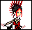 Pixel art character with red and black spiky hair, yellow eyes, wearing a red top with black accents and checkered sleeves.