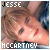 A static image of a person with light brown hair and bangs, wearing a blue patterned top, positioned above text reading "JESSE MCCARTNEY" in white capital letters.