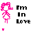 Pixel art icon of a pink cartoon girl with curly hair, wearing a dress and standing in front of text reading 'I'm In Love' that changes color across frames.