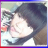 A young girl with dark hair and bangs holds a small object near her face across showing subtle expression changes