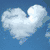 Animated cloud-shaped heart against blue sky, transitioning to skeletal hand holding colorful hearts, then black-and-white hands holding, and finally three outlined hearts in pink, blue, and green.