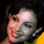 A pixelated image of a person with dark hair and light skin wearing a yellow garment, next to green text reading 'Original Icons .com' on a solid background.