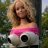 A pixelated image shows a person with light brown hair wearing a pink and white top, holding a black-and-white soccer ball outdoors.