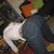 A pixelated image shows a person in dark pants and white shoes standing on a patterned floor with orange, green, and brown shapes.