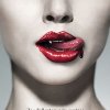 Close-up of a person's lower face showing lips, nose, and neck with red lipstick and visible teeth against a light gray background.