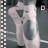 A dancing figure in white clothing with large oval shapes on the torso, positioned against a dark background with vertical filmstrip borders.