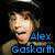 Pixelated image of a person in military-style cap with blue text "Alex Gaskarth" and pink hearts, partially obscured by gray overlay.