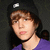 A person wearing a black beanie with white logo and purple shirt, shown in four with slight head position changes