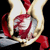 Pixelated image of a stylized figure with red and white elements against black background, featuring curved shapes resembling limbs or accessories.