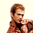 Static pixelated image of a person with brown hair wearing a red and black checkered shirt against a light background.
