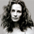 Pixelated grayscale portrait of a person with long dark hair, neutral expression, and light-colored clothing against a plain background.