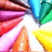 A colorful, pixelated radial pattern with alternating triangular segments in red, pink, orange, yellow, green, blue, and white.