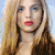 Static pixelated image of a person with long blonde hair and red lips against light blue background, rendered in low-resolution style typical of early 2000s digital art.